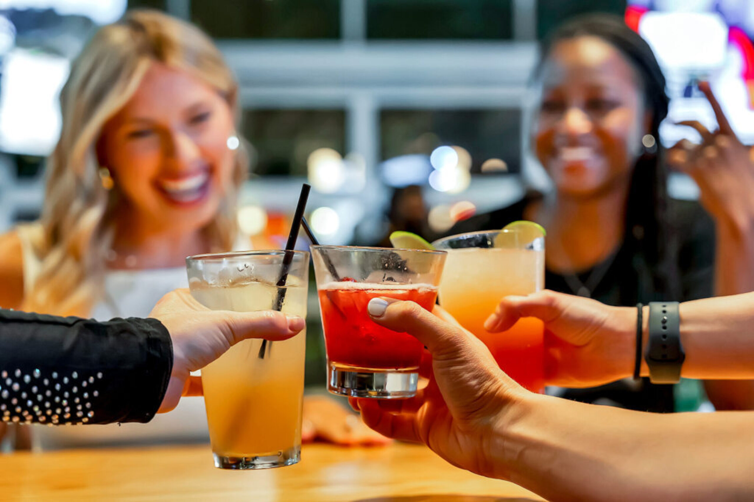 Group of women toasting cocktails at Sports & Social in Cary, NC.