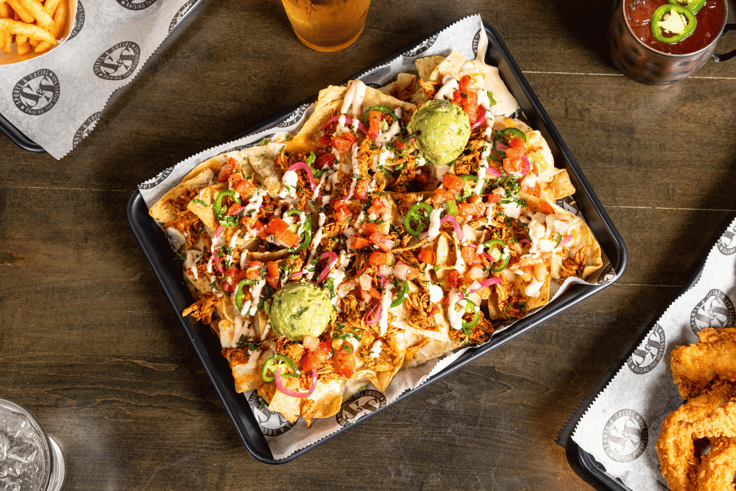 Loaded Nachos with cheddar, guacamole, shredded chicken, back beans