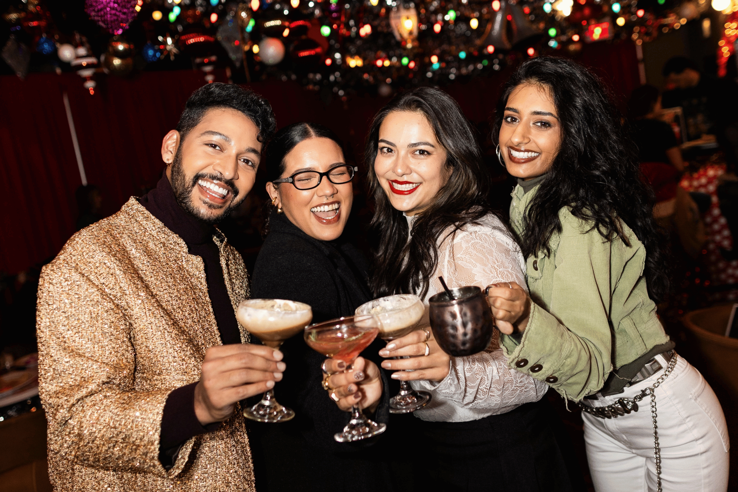 Tinsel Tavern Holiday Pop Up Bar Guests Toasting with Cocktails