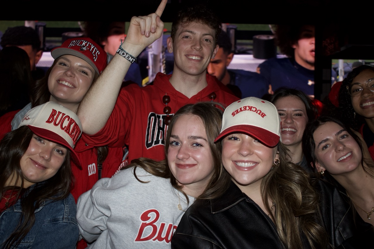 Two women and a man at Sports & Social sports bar enjoying nightlife.