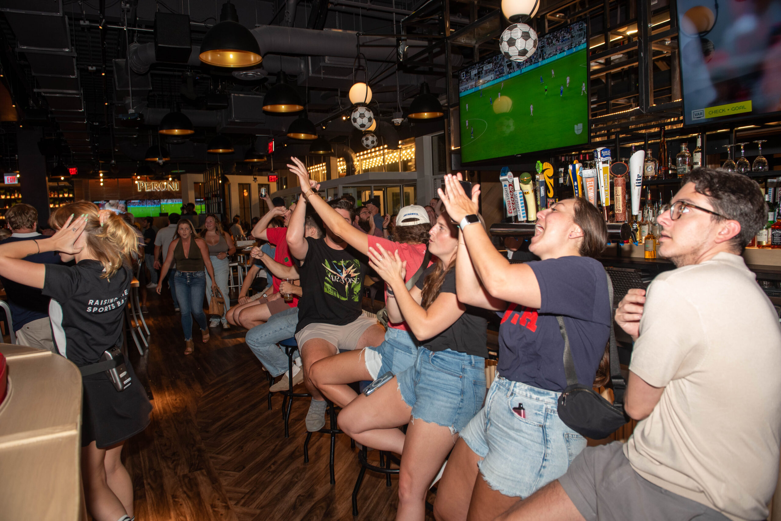 group enjoying family friendly soccer watch party at Sports & Social
