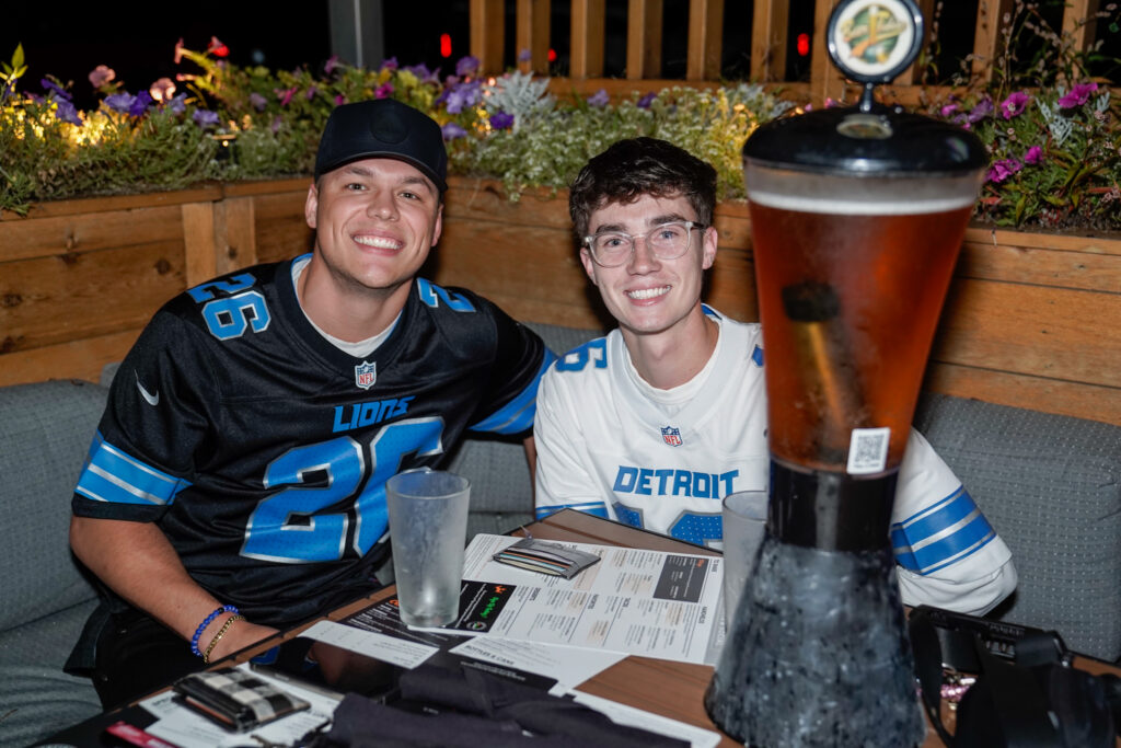 two sports fans enjoying a beer tower